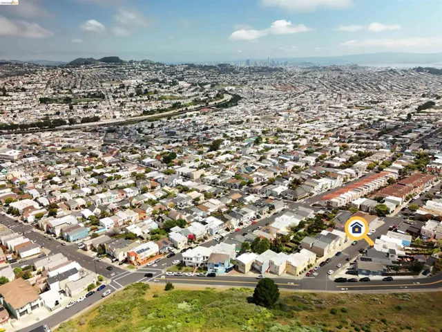 Aerial perspective showcasing a dense urban landscape with residential properties, city skyline in the distance, and surrounding hills