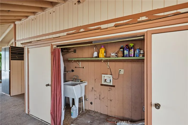 right outside kitchen is closet area covered for laundry
