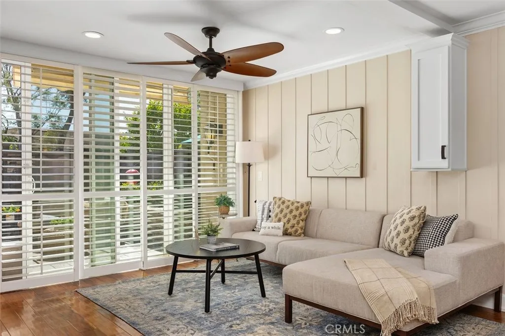 Living Room – Comfortable gathering space featuring a ceiling fan, and direct connection to the private enclosed back patio.
