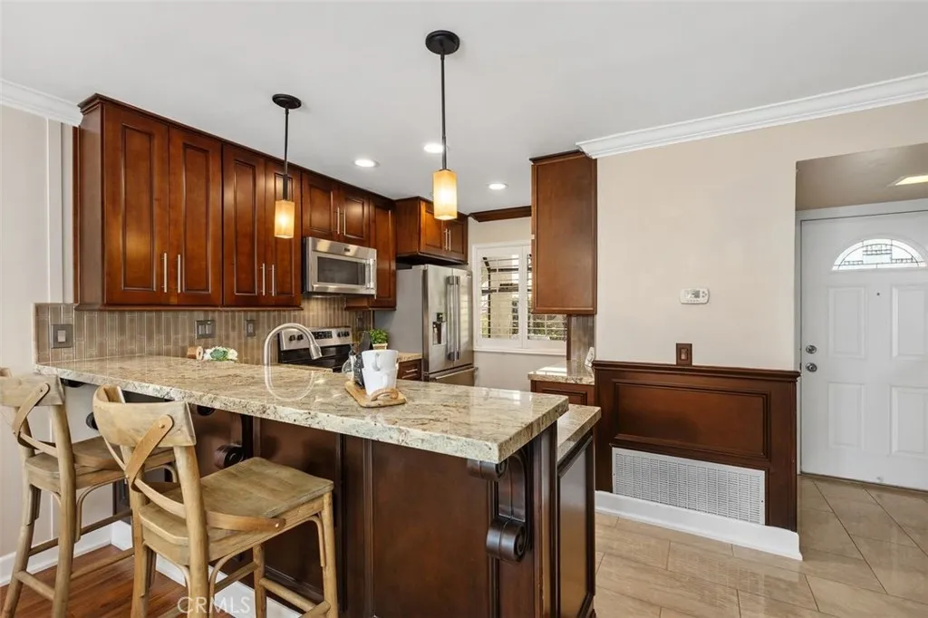 Kitchen – Well-appointed kitchen with warm cabinetry, stainless steel appliances, and generous counter space.

