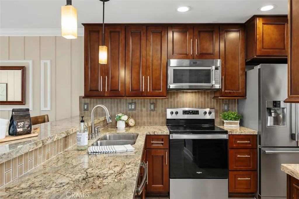 Kitchen – Kitchen workspace with stainless steel appliances, abundant cabinetry.

