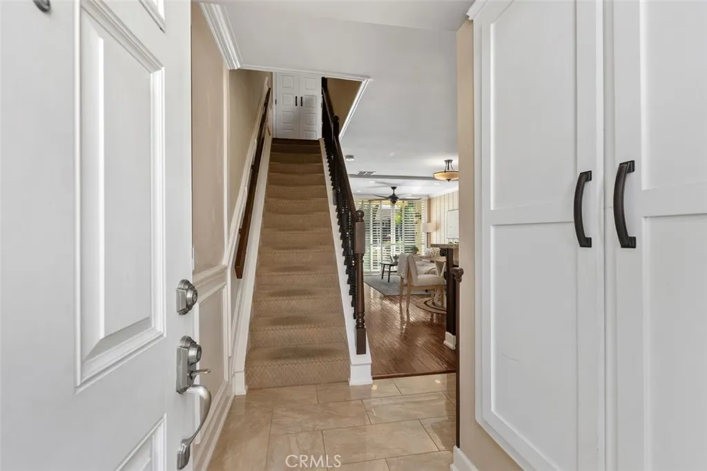 Interior Foyer – Bright stairway with updated rod iron railing, neutral walls, tile floor, and a clean transition between levels.