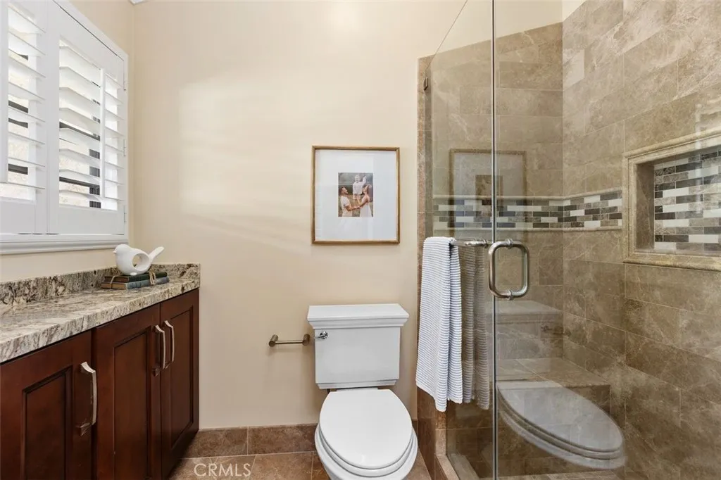 Bathroom – Extra cabinets linens, tile floors, vaulted ceiling, remodeled shower, and a clean design.
