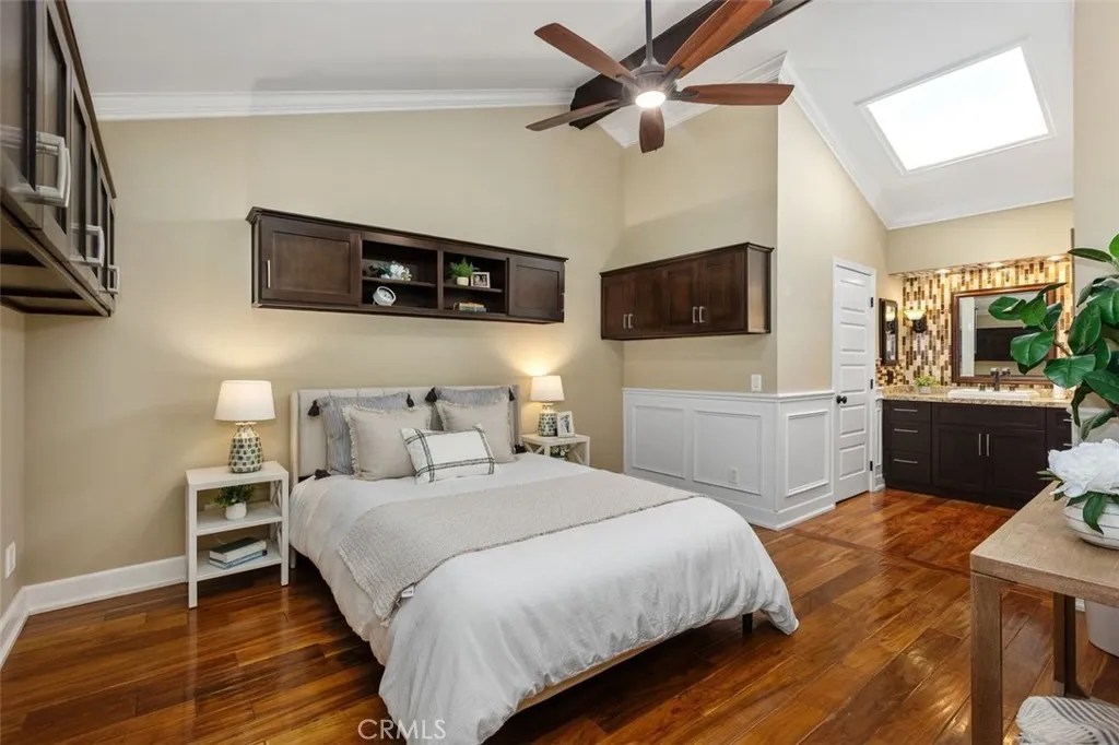 Bedroom – Comfortable bedroom with neutral finishes, hardwood flooring, and natural light from the overhead skylight.