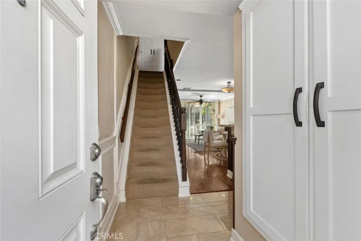 Interior Foyer – Bright stairway with updated rod iron railing, neutral walls, tile floor, and a clean transition between levels.