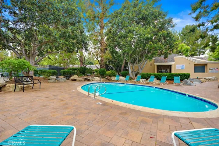 Community Pool – Elevated view of the community pool area with mature trees and open deck space.

