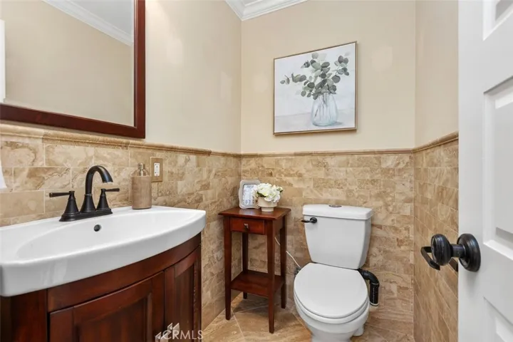 Powder Room – Convenient downstairs half bathroom, with tiled walls and updated fixtures.