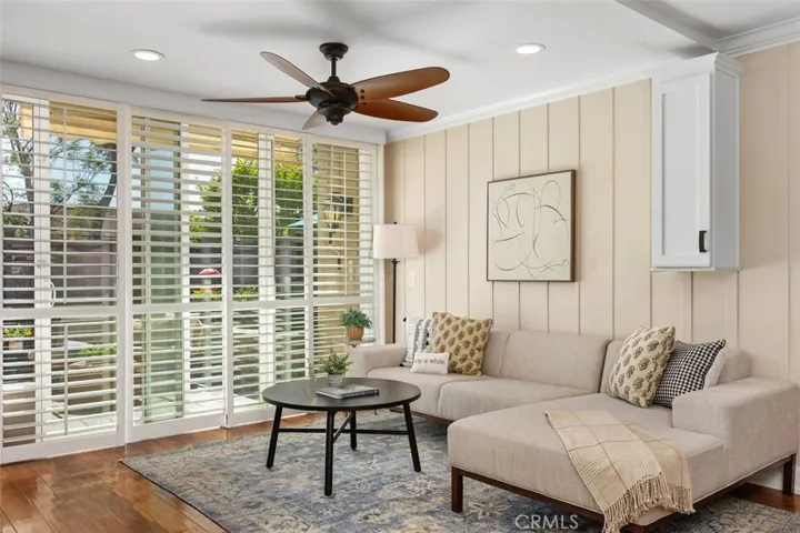 Living Room – Comfortable gathering space featuring a ceiling fan, and direct connection to the private enclosed back patio.
