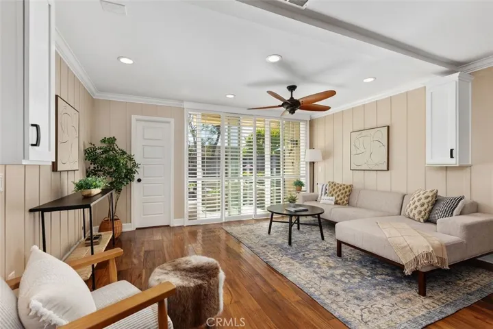Living Room – Spacious living area, ceiling fan, and large windows that bring in natural light.
