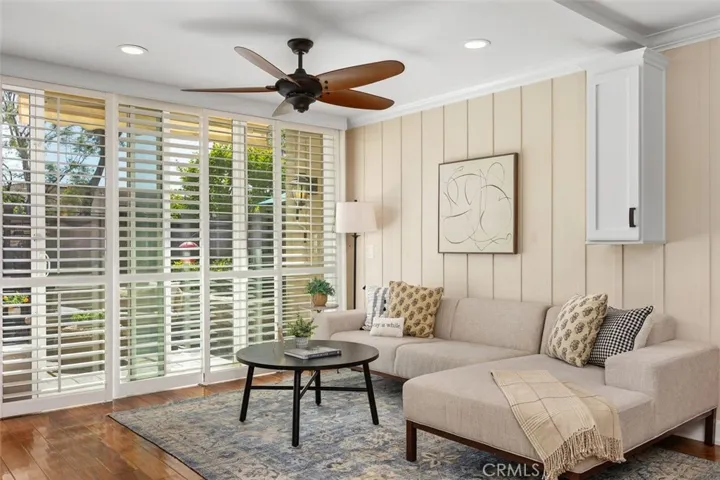 Living Room – Comfortable gathering space featuring a ceiling fan, and direct connection to the private enclosed back patio.
