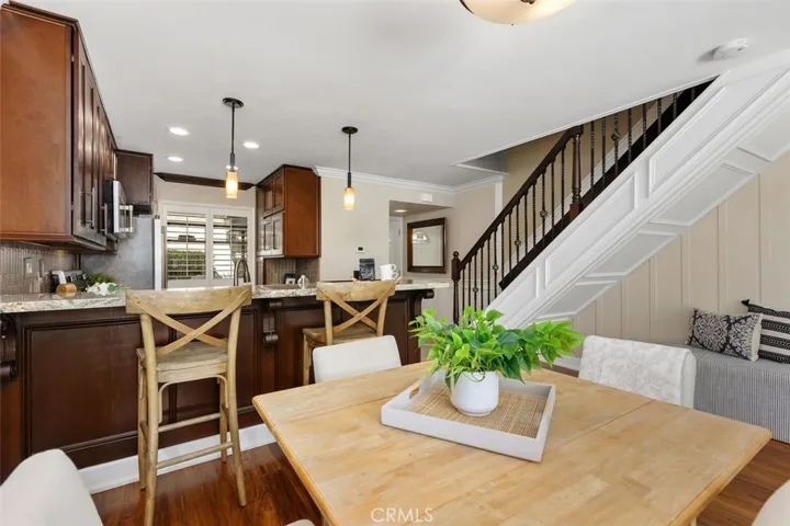 Kitchen – Functional kitchen with wood cabinetry, stainless steel appliances, and a breakfast bar overlooking the dining area.
