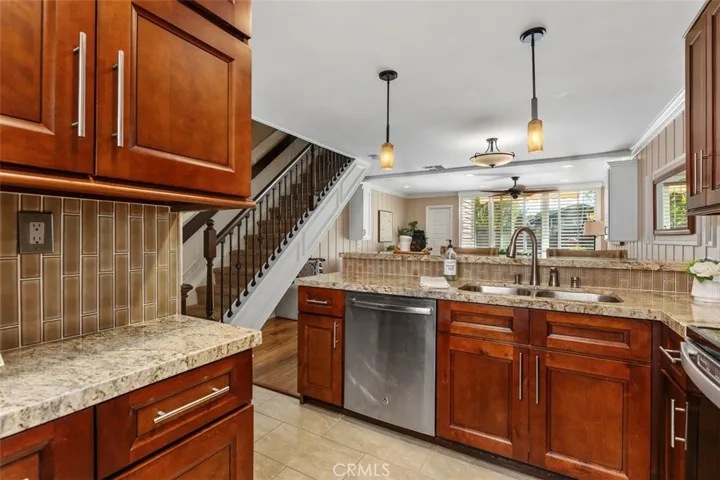 Kitchen – Fully updated with wood cabinetry, tile flooring, granite counters, and accent lighting.
