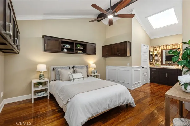 Bedroom – Comfortable bedroom with neutral finishes, hardwood flooring, and natural light from the overhead skylight.