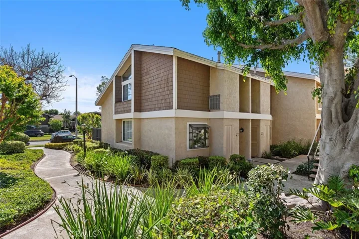 Exterior Front – Front exterior view with private entry, mature greenery, and a welcoming approach.
