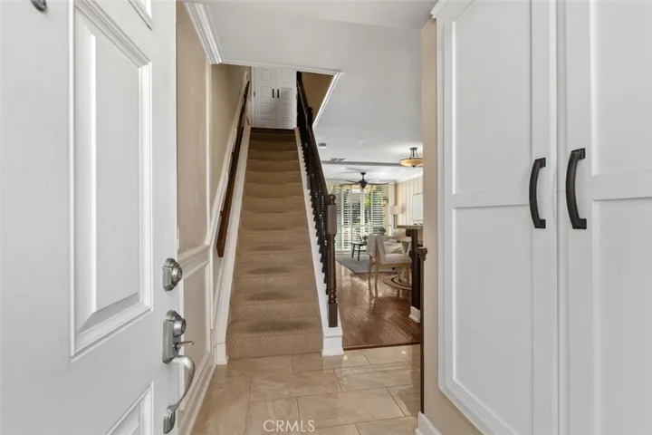 Interior Foyer – Bright stairway with updated rod iron railing, neutral walls, tile floor, and a clean transition between levels.