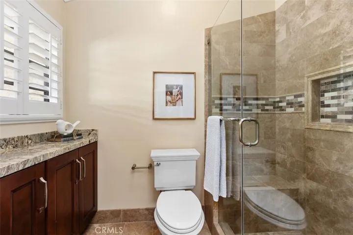 Bathroom – Extra cabinets linens, tile floors, vaulted ceiling, remodeled shower, and a clean design.
