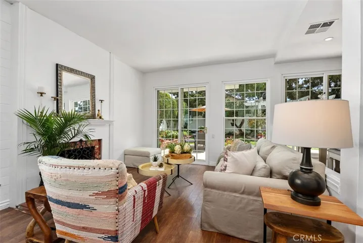 Cozy character at its best. Relax  in this sun-drenched family room complete with timeless wood flooring and cozy fireplace! A front-row seat to the lush English garden