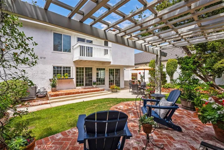 A grand perspective of a truly special property! This sweeping view from the expansive brick patio showcases the home's charm and its seamless connection to the lush, private grounds of this premier corner lot. The ultimate backdrop for quiet afternoons or large-scale entertaining.