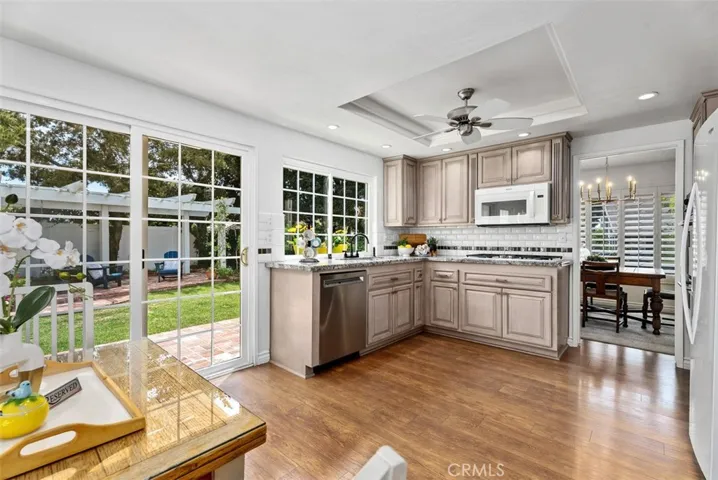 A cheerful sunlit kitchen where every window offers a view of your private garden oasis.
