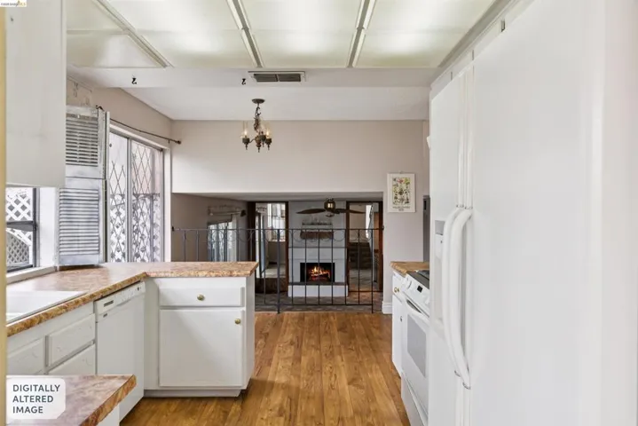 Kitchen featuring white cabinetry, light-toned countertops, and wood-finish flooring