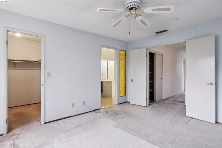 Carpeted room with a ceiling fan light fixture