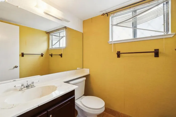 Bathroom with a dark wood-finish vanity, integrated sink, and light-toned countertop