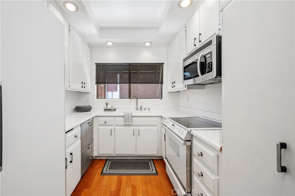 Efficient kitchen with electric range/oven, microwave, dishwasher, refrigerator.