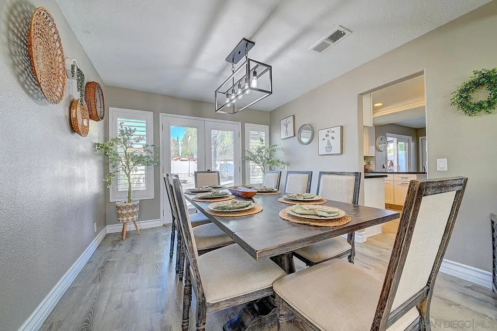 Set the table and make memories. Rustic trestle table, designer cage chandelier, French doors to the patio, and an open pass-through to the kitchen — dinner parties start and end right here.