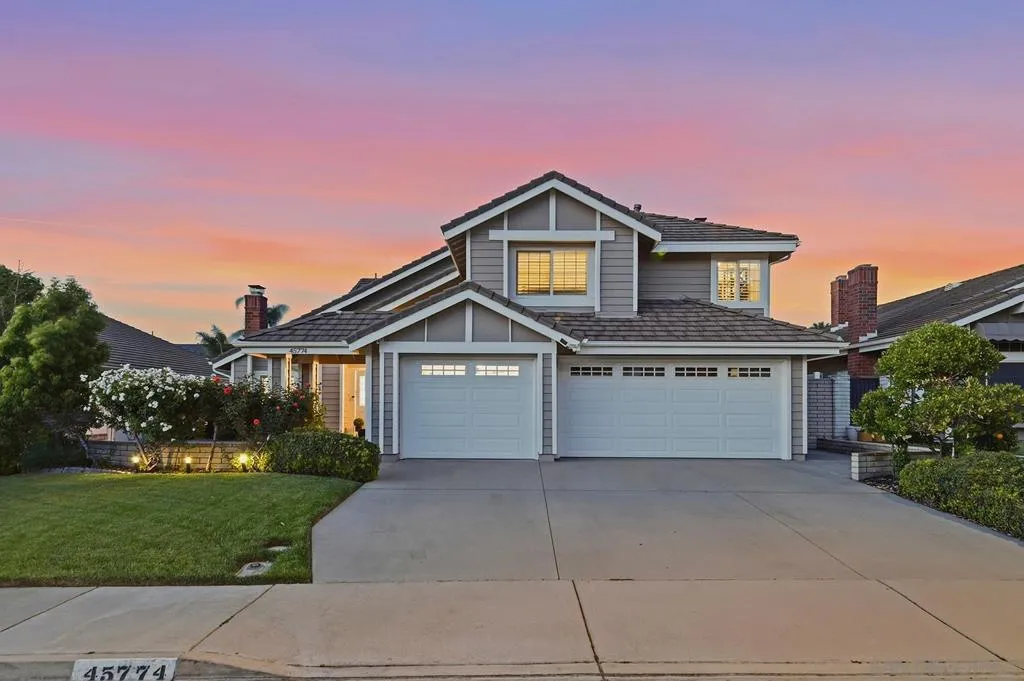 45774 Hopactong Street — stunning craftsman curb appeal, 3-car garage, manicured landscaping, and a glowing sunset sky. This is what coming home feels like every night.