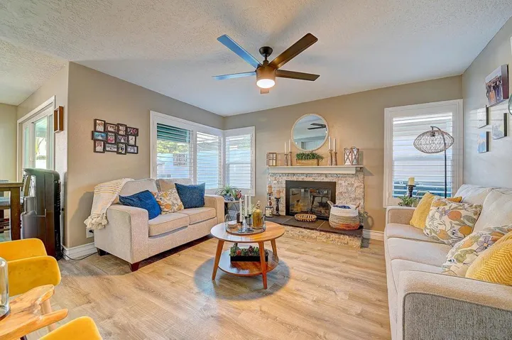 Warm, inviting, and built for living. Stone fireplace with custom mantle, updated ceiling fan, luxury vinyl plank flooring, and a layout that flows directly to the backyard — cozy enough for quiet nights, open enough for the whole crowd.