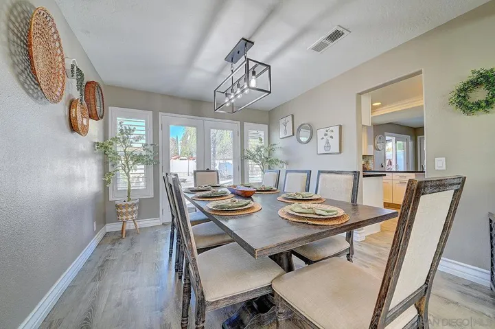 Set the table and make memories. Rustic trestle table, designer cage chandelier, French doors to the patio, and an open pass-through to the kitchen — dinner parties start and end right here.