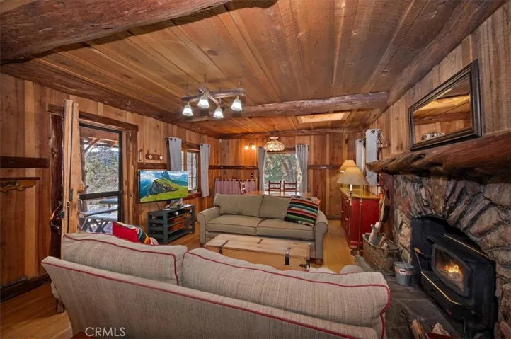 Living Room boosts a wood Burning Stove in a  stone fireplace