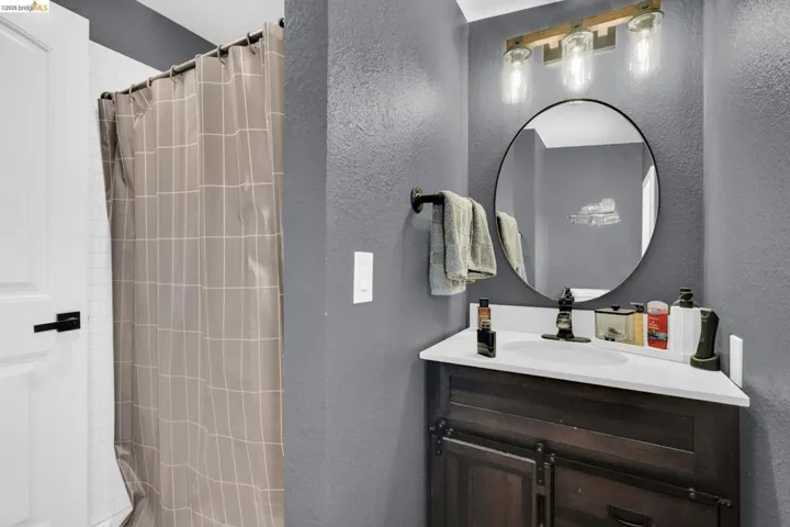 Bathroom featuring a dark wood-finish vanity with a white countertop and integrated sink