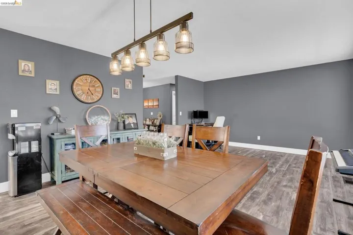 Dining area featuring a linear multi-light fixture, wood-finish flooring, and a built-in buffet cabinet