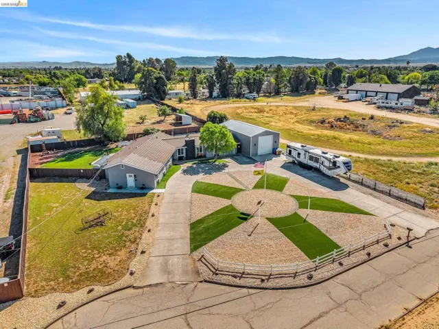 Expansive driveway featuring a decorative compass rose design with gravel and artificial turf