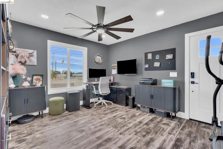 Versatile room featuring wood-finish flooring, a contemporary ceiling fan, and recessed lighting