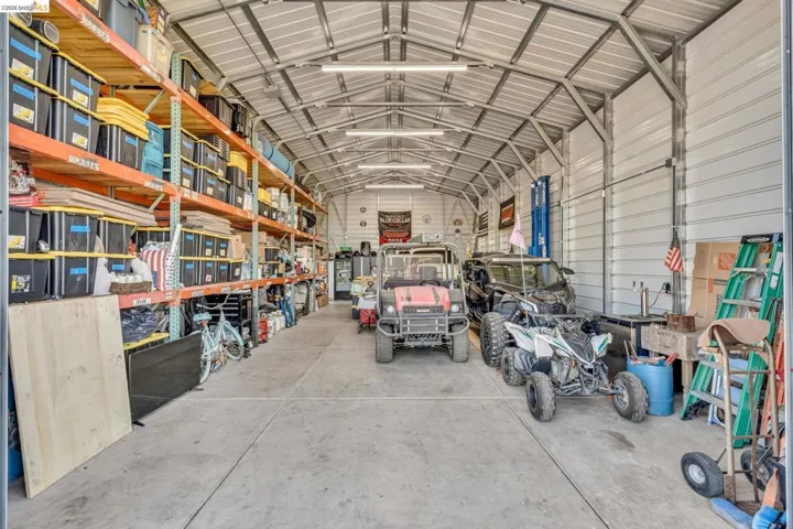 Spacious metal building interior featuring a concrete floor and exposed metal truss ceiling