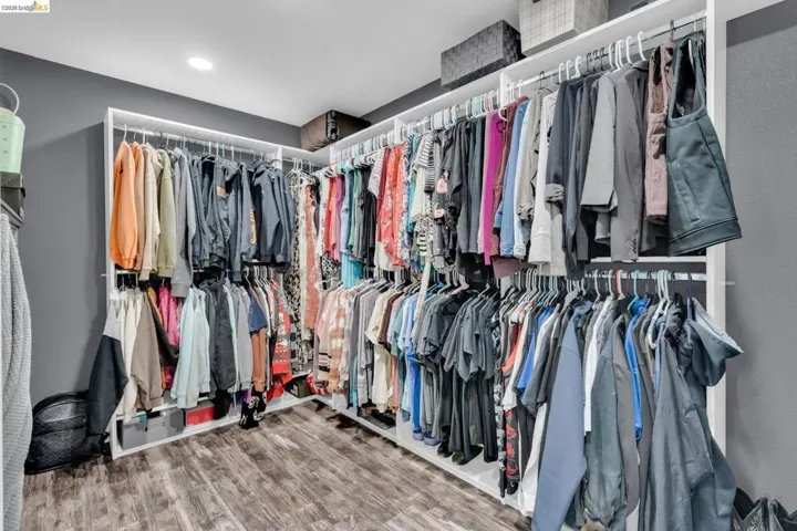Custom closet system featuring white shelving and multiple hanging rods