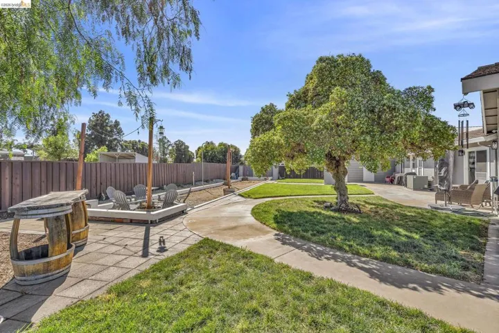 Outdoor lounge area with a built-in fire pit, surrounded by a wood privacy fence
