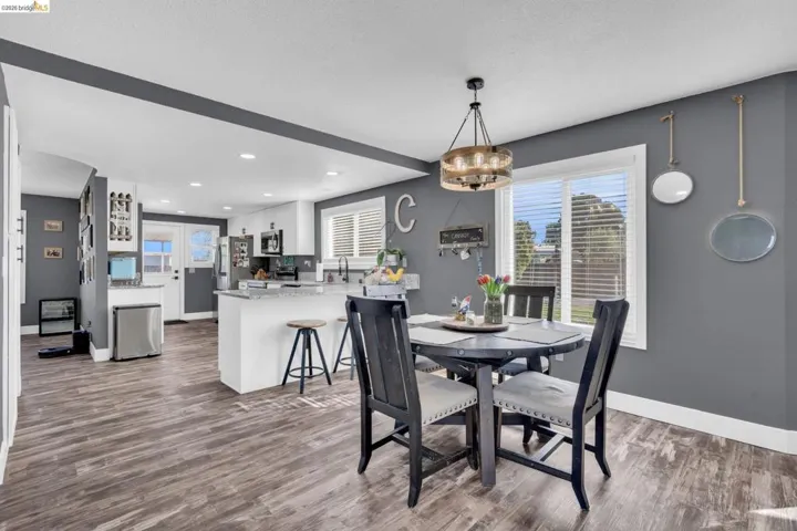 Open-concept living space featuring wood-finish flooring, a modern chandelier, and recessed lighting