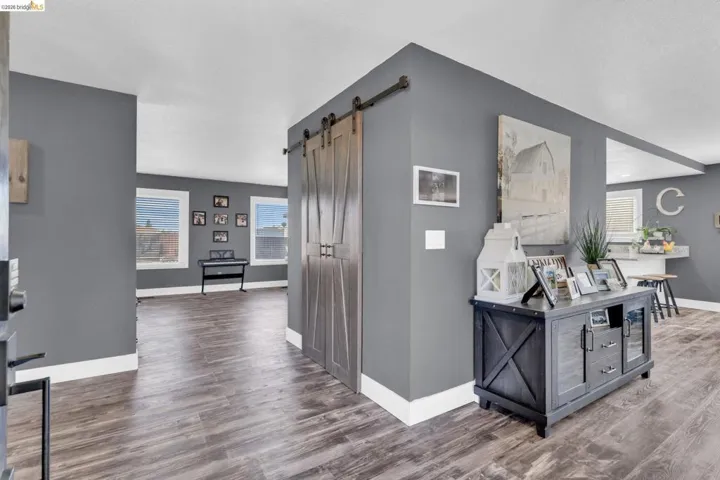 Interior featuring wood-finish flooring, a sliding barn door, and a dedicated entry space with deep gray walls