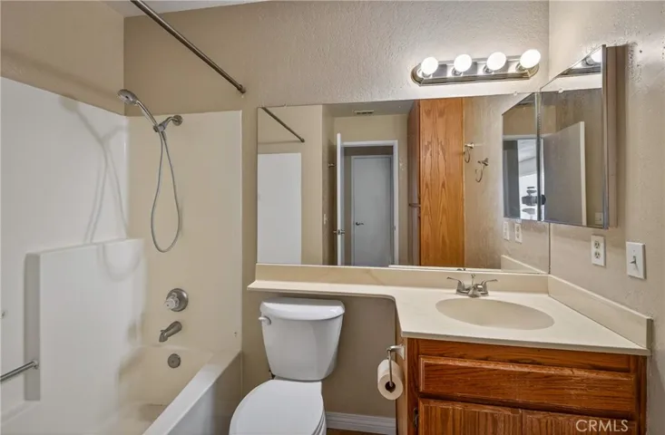 Guest Bathroom with Shower over Tub and tile flooring