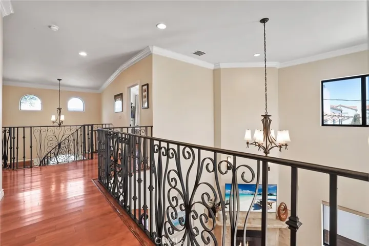 Custom iron railing and banister accentuates the balcony and staircase.