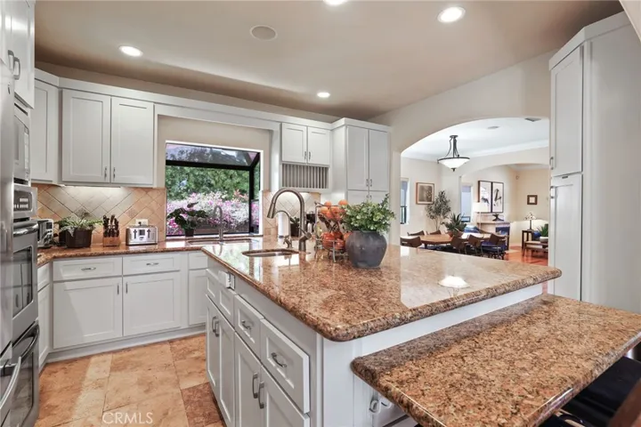 The kitchen features a large center island with utility sink and lots of storage!