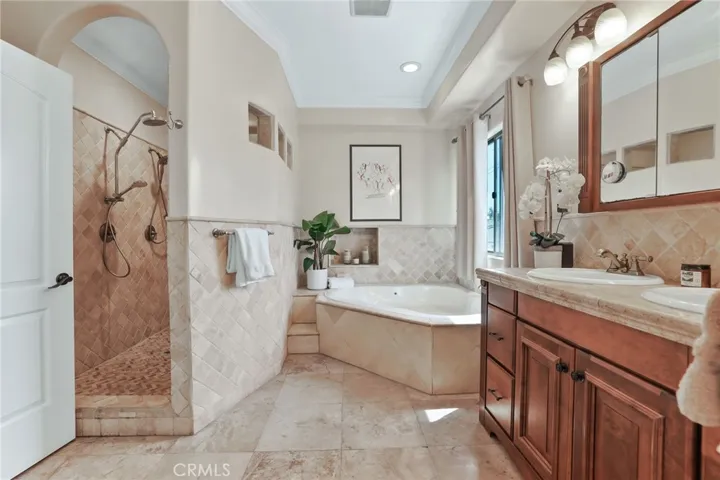 Take a long soak in the tub or a quick shower! This en suite offers options with double sinks and lots of storage  accented by beautiful stone tile.
