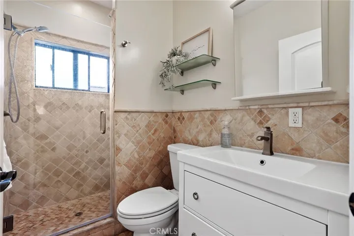 Downstairs guest bathroom features beautiful stone tile in the large walk-in shower.