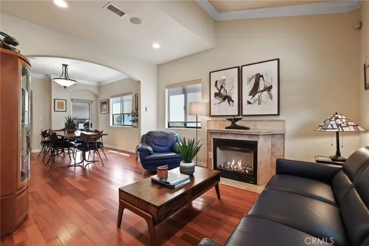 Living room view of cozy fireplace and open to dining room.