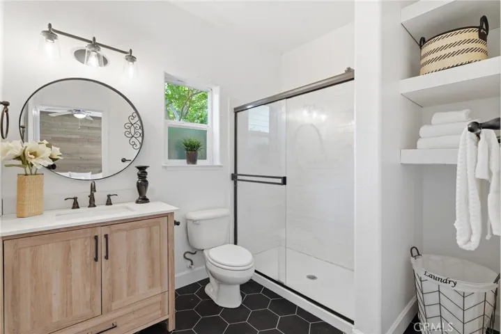 Primary ensuite with newer vanity, hex tile flooring and walk in shower.