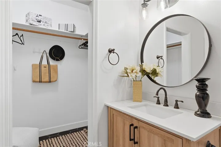 Primary ensuite with newer vanity, hex tile flooring and walk in closet