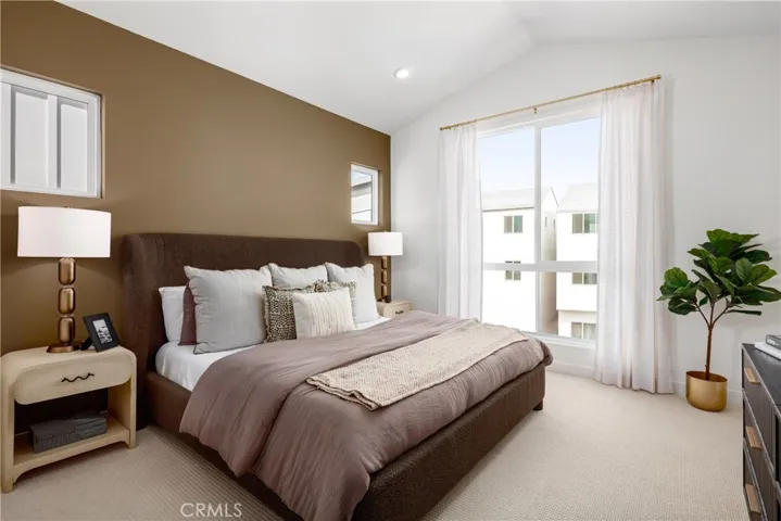 Model home primary bedroom with vaulted ceilings,